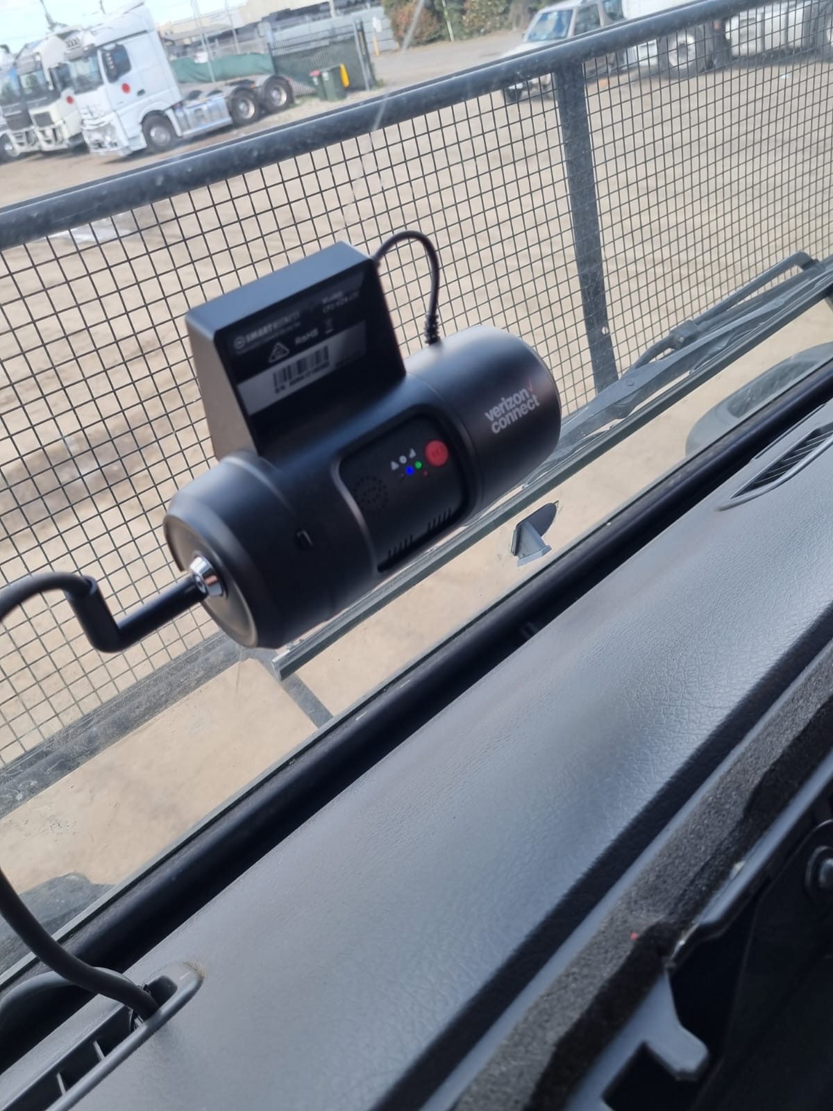 Installer securing a dash camera to a vehicle windscreen